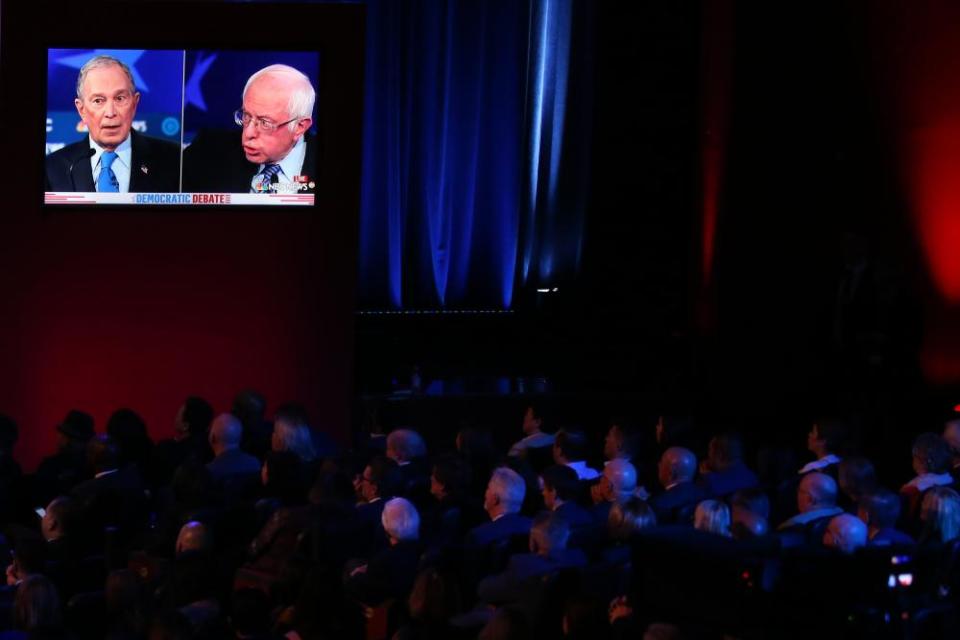 Audience members watch democratic presidential candidates Mike Bloomberg and Bernie Sanders speak on a monitor during the Democratic presidential primary debate in Las Vegas, Nevada.