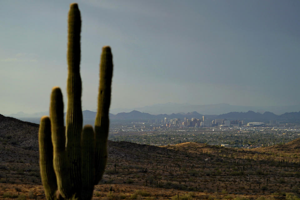 FILE - The sun sets over Phoenix, July 30, 2023. Across the U.S., many people are living through one of the most brutal summers of their lives and reckoning with the idea that climate change is only going to make matters worse in the coming decades. (AP Photo/Matt York, File)