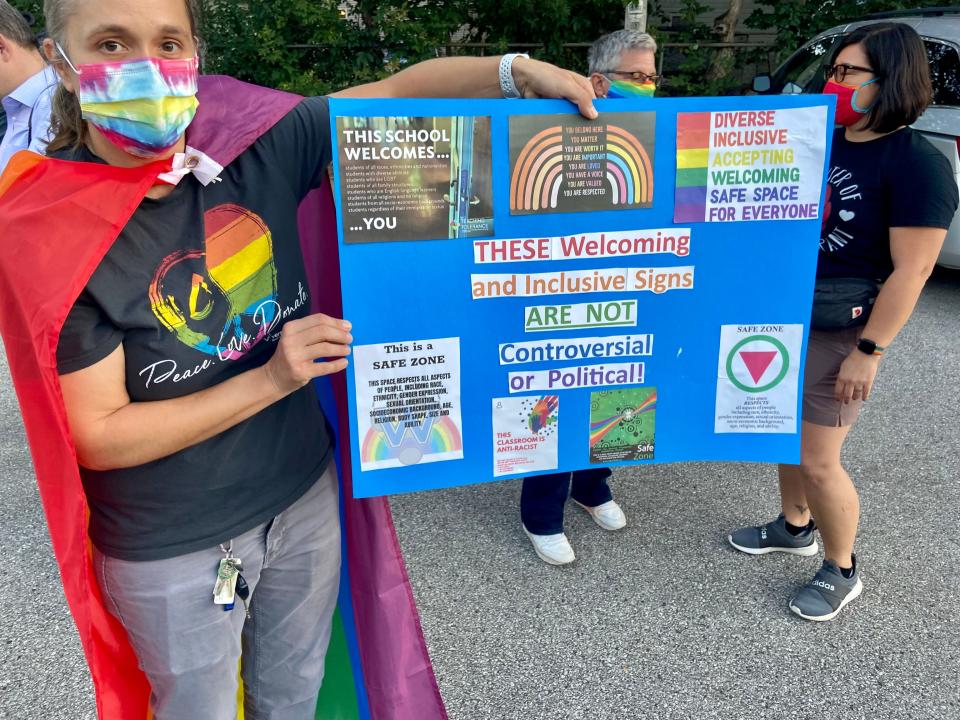 Greta Voit, a physics teacher in Waukesha, Wis., protests a district ban on inclusive signage before a school board meeting in September. Teachers can no longer display “safe space” posters, Black Lives Matter signs, thin blue line signs or Pride flags in classrooms, on the grounds they’re too political.