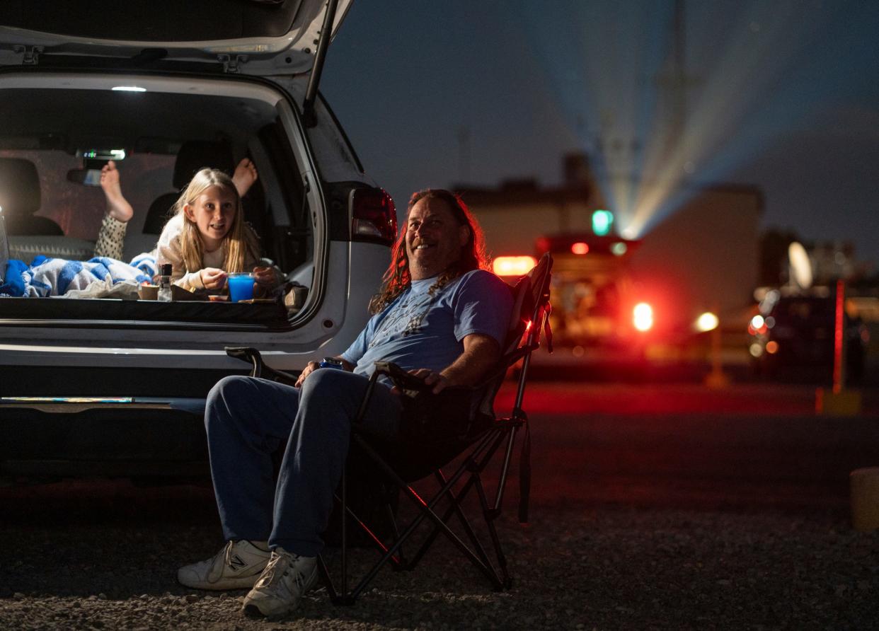 Dave Urbanczyk, of Warren, shares a laugh with his daughter Abigail Urbanczyk as she lays in the back of their vehicle while they watch "Despicable Me 4" together at the Ford-Wyoming Drive-In in Dearborn on Thursday, July 18, 2024. "This is something that the families did, and they did it all the time. It's a memory I'll never forget. My kids never forgot it. She ain't never going forget it. They need drive-ins," he said.