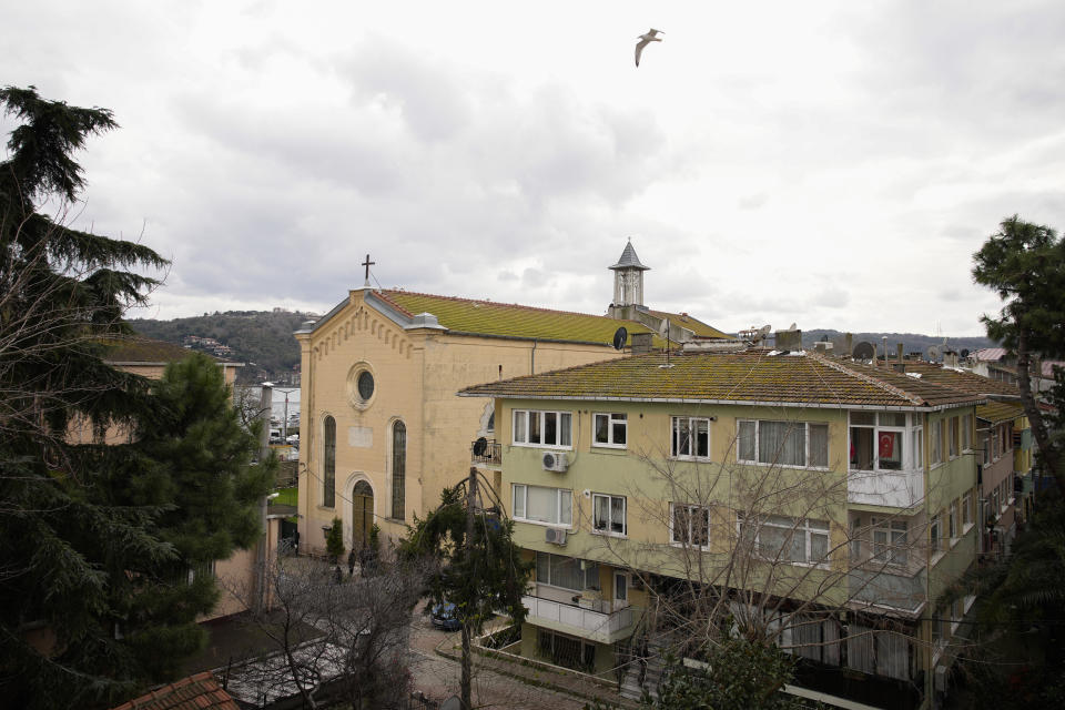 Turkish police officers guard a cordoned off area outside Santa Maria church, left, in Istanbul, Turkey, Sunday, Jan. 28, 2024. Two masked assailants attacked a church in Istanbul during Sunday services, killing one person, Turkish officials said. (AP Photo/Emrah Gurel)