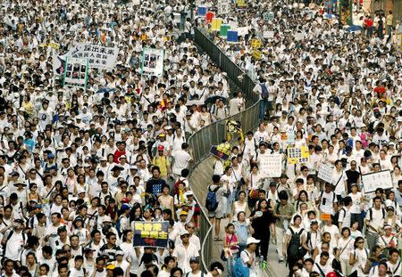 Demonstrators crowd a main street at a Hong Kong shopping district during a rally, July 1, 2004. Hundreds of thousands of protesters hit the streets on the 7th anniversary of the handover after China ruled out the possibility of universal suffrage in Hong Kong in 2007 and 2008, further slowing the pace of political reform. Beijing also ruled that it must approve changes to Hong Kong's election laws, effectively vetoing any moves towards more democracy. REUTERS/Bobby Yip/File photo