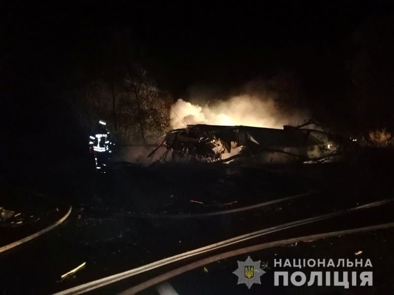 A rescuer inspects wreckages of the Ukrainian military Antonov An-26 plane after crashing outside of Chuhuiv town