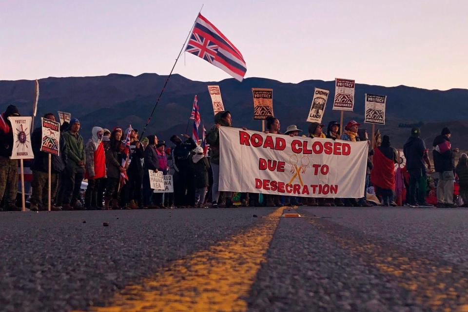 In this July 15, 2019 file photo, demonstrators block a road at the base of Hawaii's tallest mountain, in Mauna Kea, Hawaii, to protest the construction of a giant telescope on land that some Native Hawaiians consider sacred.