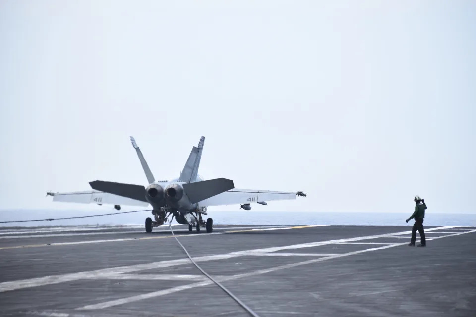 A fighter jet lands on the deck of the USS Dwight D. Eisenhower.