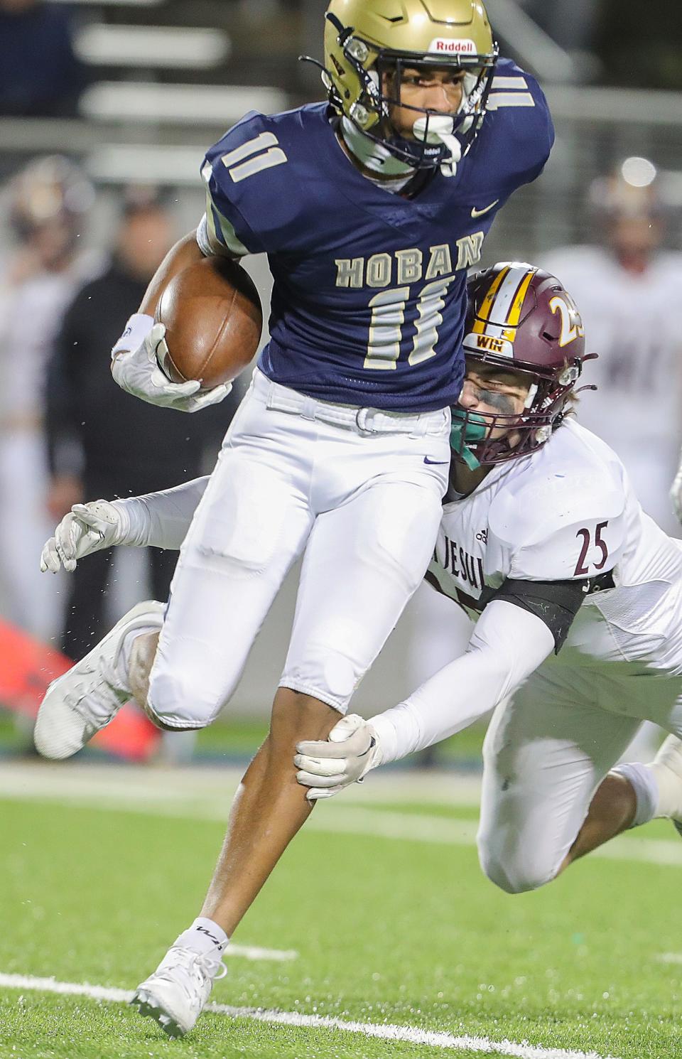 Walsh Jesuit linebacker Alex Dachille makes the stop on Hoban receiver Elbert Hill IV in a Division II regional final Friday in Akron.