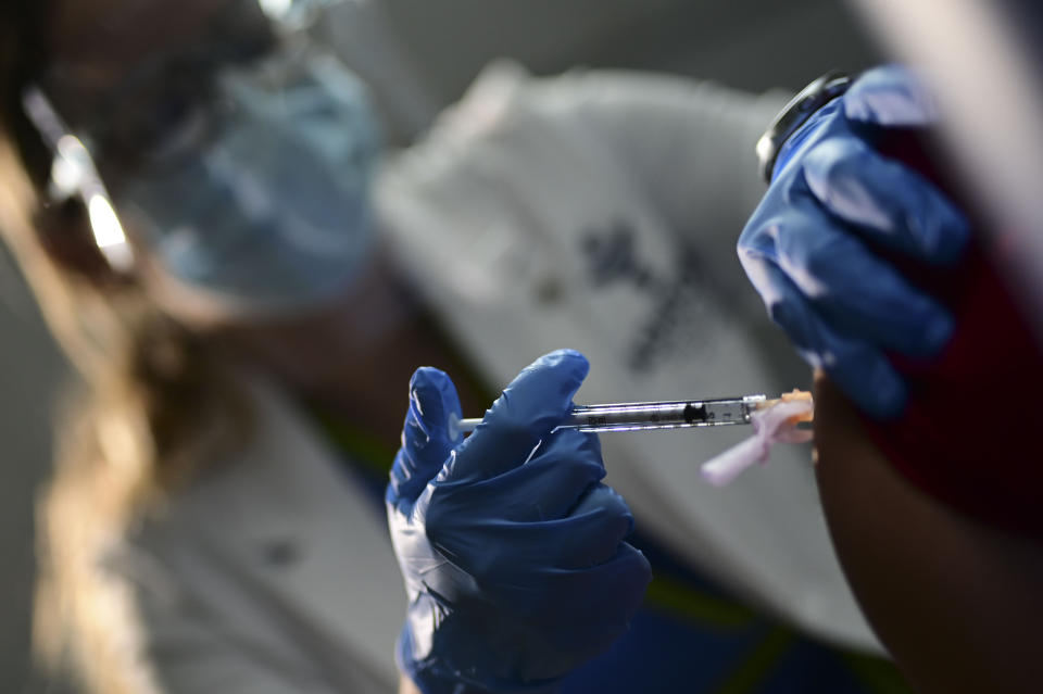 La enfermera Melissa Valentín aplica la vacuna de Pfizer y BioNTech contra el COVID-19 a un trabajador de salud el martes 15 de diciembre de 2020, en el Ashford Presbyterian Community Hospital, en San Juan, Puerto Rico. (AP Foto/Carlos Giusti)