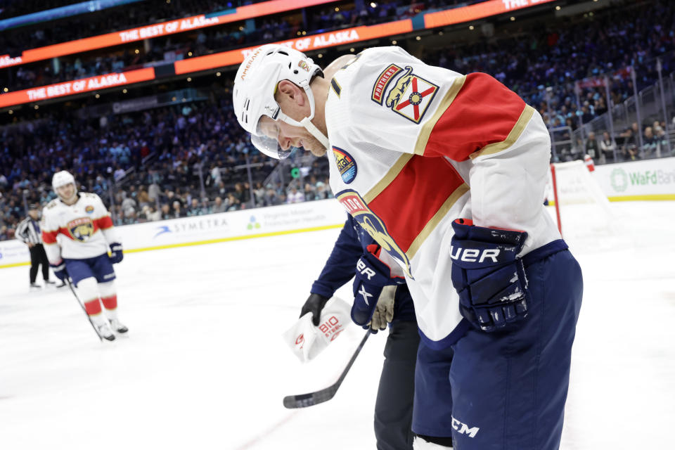 FILE - Florida Panthers right wing Patric Hornqvist (70) skates with help from team personnel after he went down on the ice against the Seattle Kraken during the second period of an NHL hockey game, Dec. 3, 2022, in Seattle. Hornqvist will not play in the Stanley Cup Final for the Florida Panthers because of a December concussion, but the team insists he is still a big part of their success. (AP Photo/John Froschauer, File)