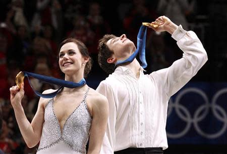 Canada's Virtue and Moir hold up their gold medals during medals ceremony for ice dance figure skating event at Vancouver Winter Olympics