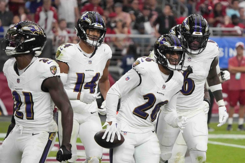 Baltimore Ravens safety Geno Stone (26) celebrates his interception with teammates during the second half of an NFL football game against the Arizona Cardinals Sunday, Oct. 29, 2023, in Glendale, Ariz. (AP Photo/Rick Scuteri)