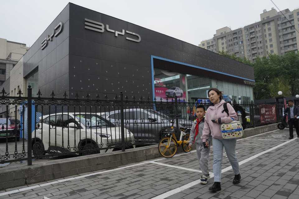 Residents past by a Seagull electric vehicle from Chinese automaker BYD parked at a showroom in Beijing, Wednesday, April 10, 2024. The tiny, low-priced electric vehicle called the Seagull has American automakers and politicians trembling. The car, launched last year by Chinese automaker BYD, sells for around $12,000 in China. But it drives well and is put together with craftsmanship that rivals U.S.-made electric vehicles that cost three times as much. Tariffs on imported Chinese vehicles probably will keep the Seagull away from America’s shores for now.(AP Photo/Ng Han Guan)