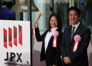 Japan's Prime Minister Shinzo Abe (R) and Japanese Paralympic athlete Mami Sato pose before she rings a bell during a ceremony marking the end of trading in 2013 at the Tokyo Stock Exchange (TSE) in Tokyo December 30, 2013. REUTERS/Yuya Shino