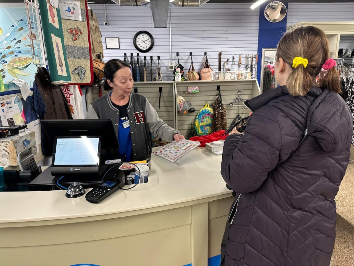 A customer makes a purchase at the Society Shoppe Resale Store on Lauzon Road. (Dale Molnar/CBC News - image credit)