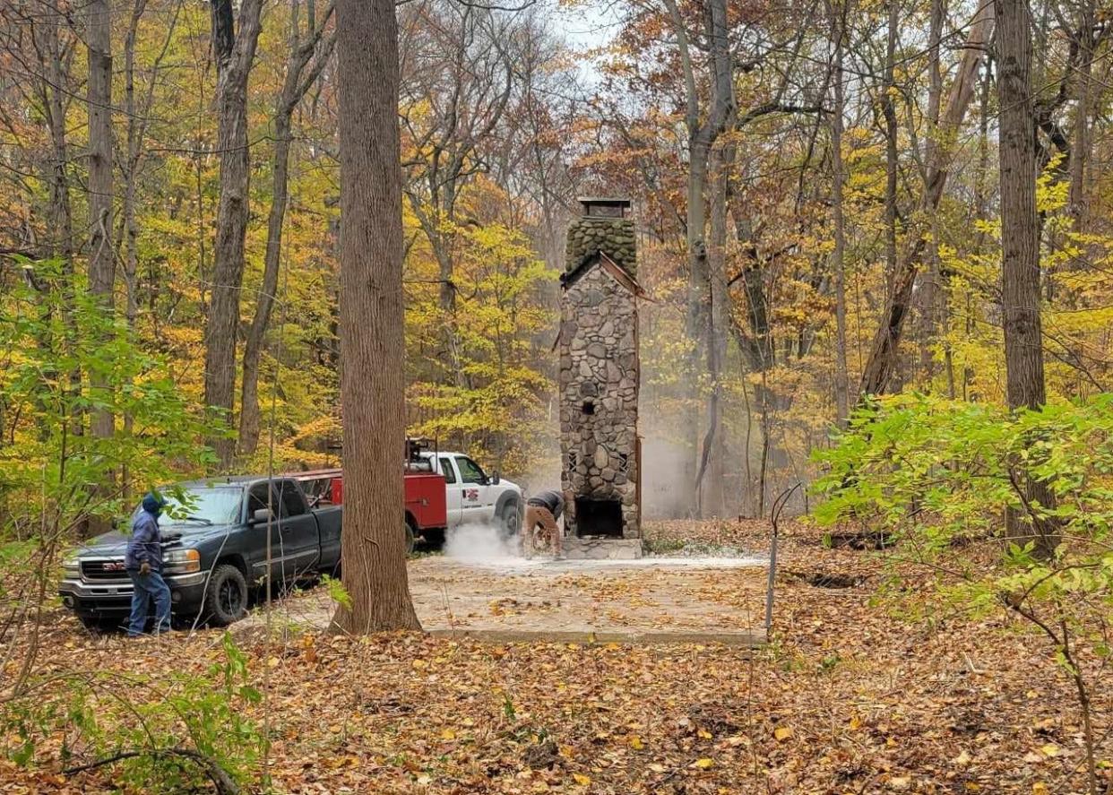 Workers try to save the fireplace and chimney of the old cabin at Love Creek County Park in Berrien Center in November 2023. Ultimately, they had to remove state stonework, too.