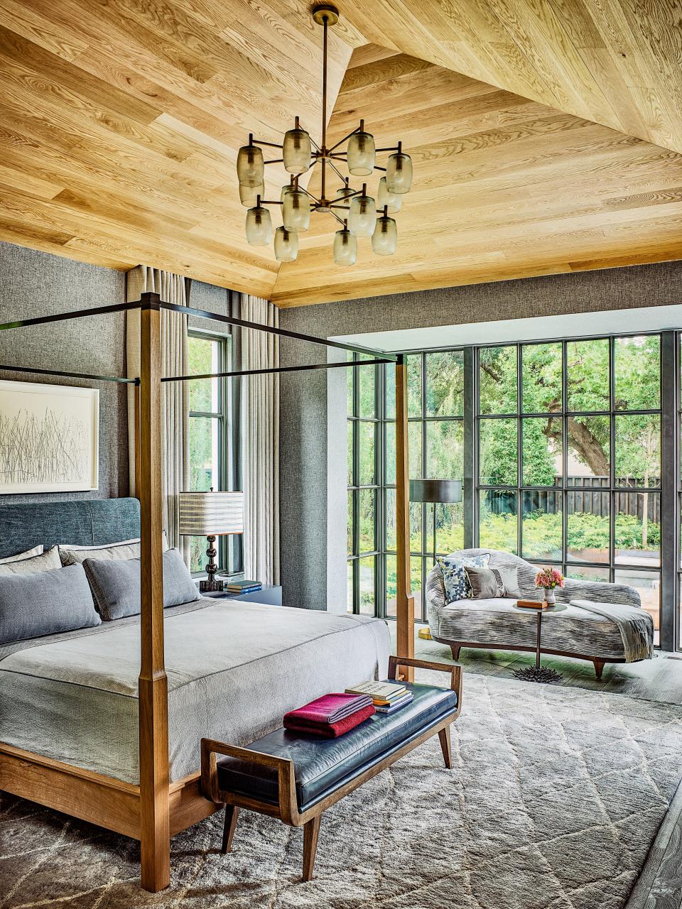 The master bedroom is furnished with a Holly Hunt bed and a bench and lighting by Arteriors.