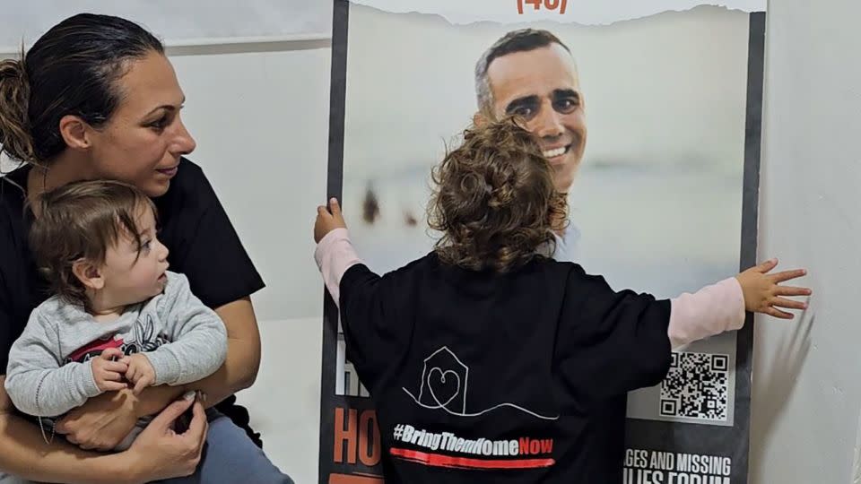 Lishay Lavi and her daughters Roni and Alma with a poster of their kidnapped husband and father Omri Miran. - Courtesy Lishay Lavi