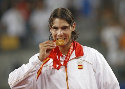 El astro español del tenis Rafael Nadal muerde la medalla de oro conquistada en los Juegos Olímpicos de Pekín el 17 de agosto de 2008. Nadal anunció el 19 de julio que no competirá en los Juegos de Londres (AFP/Archivo | behrouz mehri)