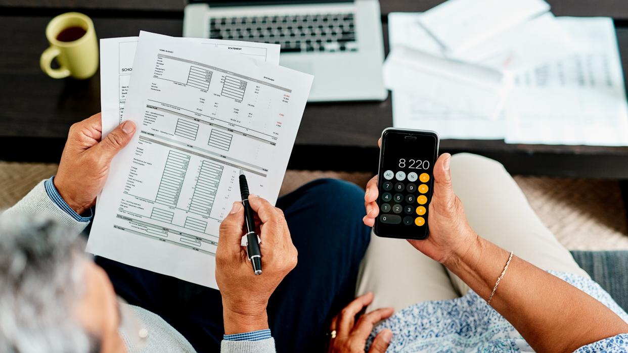 High angle shot of a couple calculating their finances together at home.