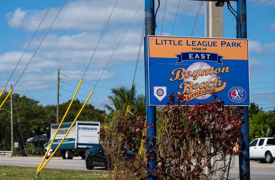 Cars are seen driving on Woolbright Road by the entrance signage at the East Boynton Little League Complex on Tuesday, February 7, 2023, in Boynton Beach, FL. Sports agent and Palm Beach County resident Phil Terrano, who grew up playing little league baseball at the complex, wants to build a baseball training facility adjacent to the Little League fields that would benefit athletes of all levels.