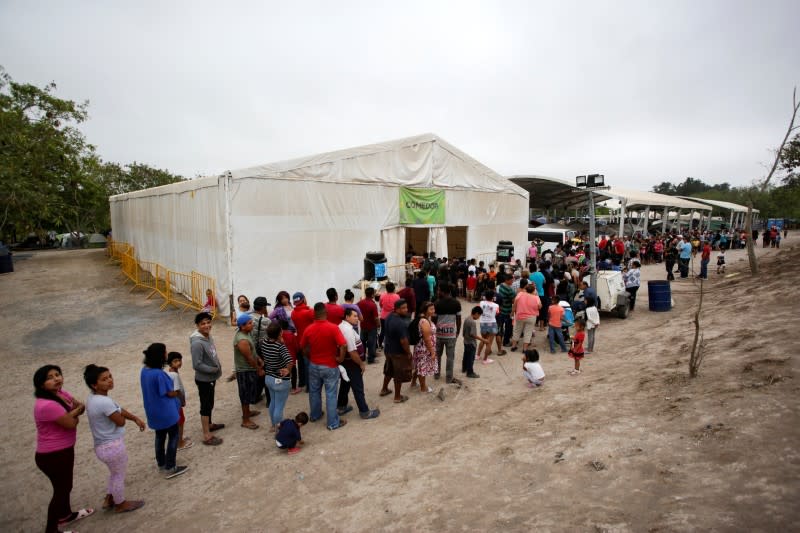 Migrants seeking asylum in the U.S. queue for food at an encampment of more than 2,000 migrants, as local authorities prepare to respond to the coronavirus disease (COVID-19) outbreak, in Matamoro