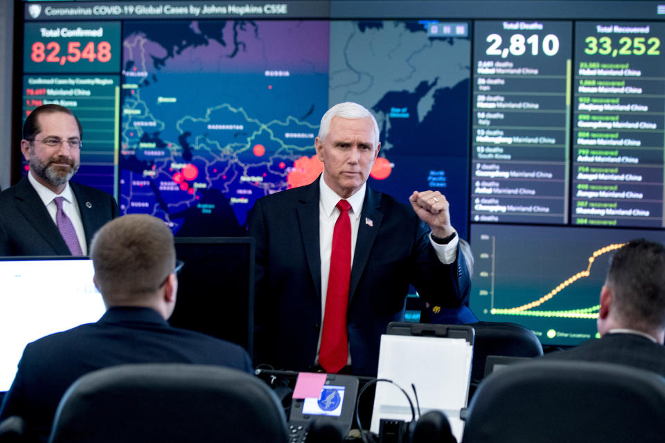 A large monitor displaying a map of Asia and a tally of total coronavirus cases, deaths, and recovered, is visible behind Vice President Mike Pence, center, and Health and Human Services Secretary Alex Azar, left, as they tour the Secretary's Operations Center following a coronavirus task force meeting at the Department of Health and Human Services in Washington, D.C., on Feb. 27, 2020.<span class="copyright">Andrew Harnik—AP</span>