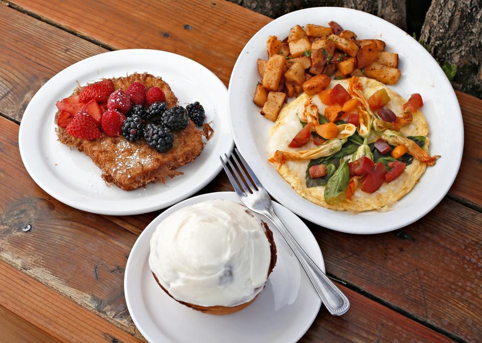 Seasonal French toast (clockwise form upper left), a squash blossom omelette, and a cinnamon roll from the Original Breakfast House.