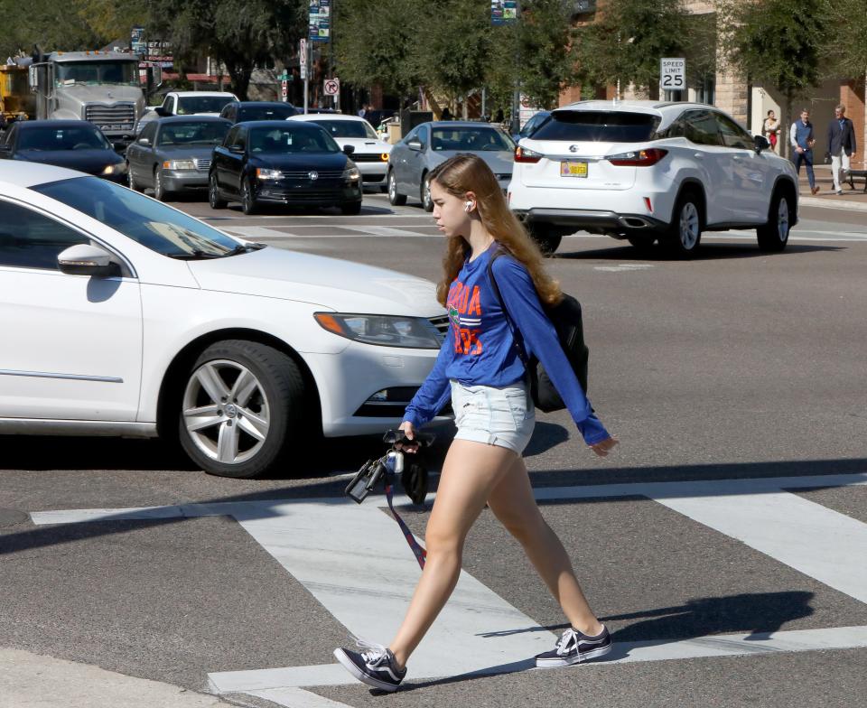 A University of Florida student just gets the end of the crosswalk as a car turns onto University Avenue, in Gainesville Fla. October 27, 2021. Pedestrian safety in a major topic in the upcoming local Gainesville City Commission race.