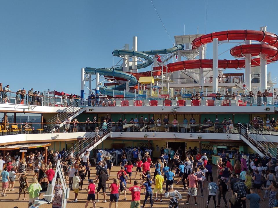 Line dance party on pool deck of Carnival cruise ship Lori A. May mistakes first time cruisers make
