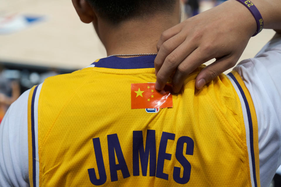 Basketball - NBA China Games - Los Angeles Lakers v Brooklyn Nets - Shenzhen, China - October 12, 2019. A fan is seen wearing LeBron James jerseys with an NBA logo covered by a Chinese national flag sticker during the game. REUTERS/Tyrone Siu