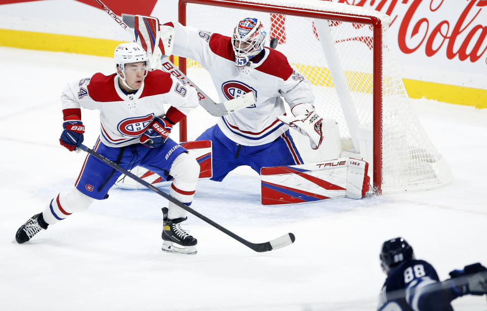 Montreal Canadiens' Jordan Harris (54) deflects a shot by Winnipeg Jets' Nate Schmidt (88) toward goaltender Sam Montembeault (35) during second-period NHL hockey game action in Winnipeg, Manitoba, Thursday, Nov. 3, 2022. (John Woods/The Canadian Press via AP)