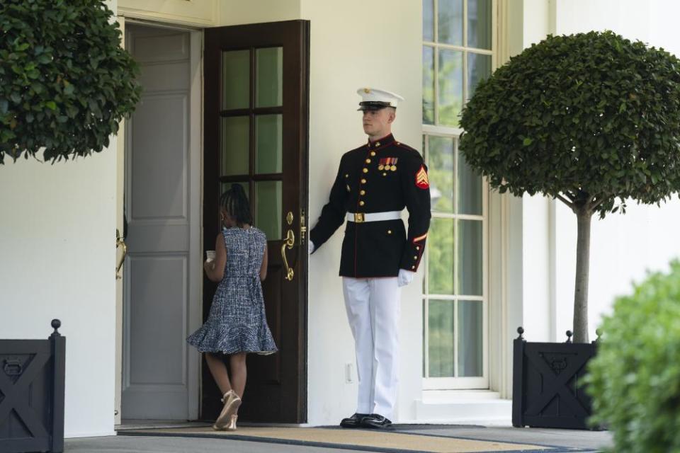 A marine holds the door as Gianna Floyd, the daughter of George Floyd, walks into the White House.