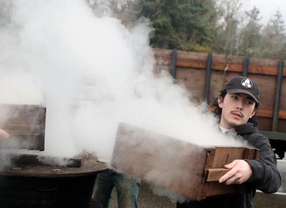 Leo Uyekawa removes a wooden tray of steamed sweet rice from the fire during Mochi Tsuki at Bainbridge Island’s Woodward Middle School on Saturday, Jan. 6, 2024.