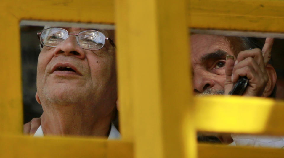 People watch a display screen on the facade of the the Bombay Stock Exchange (BSE) building in Mumbai , India, Monday Feb. 17, 2014. India's Finance Minister P. Chidambaram has unveiled a conservative budget for the government’s remaining time in office through May in parliament. (AP Photo/Rafiq Maqbool)