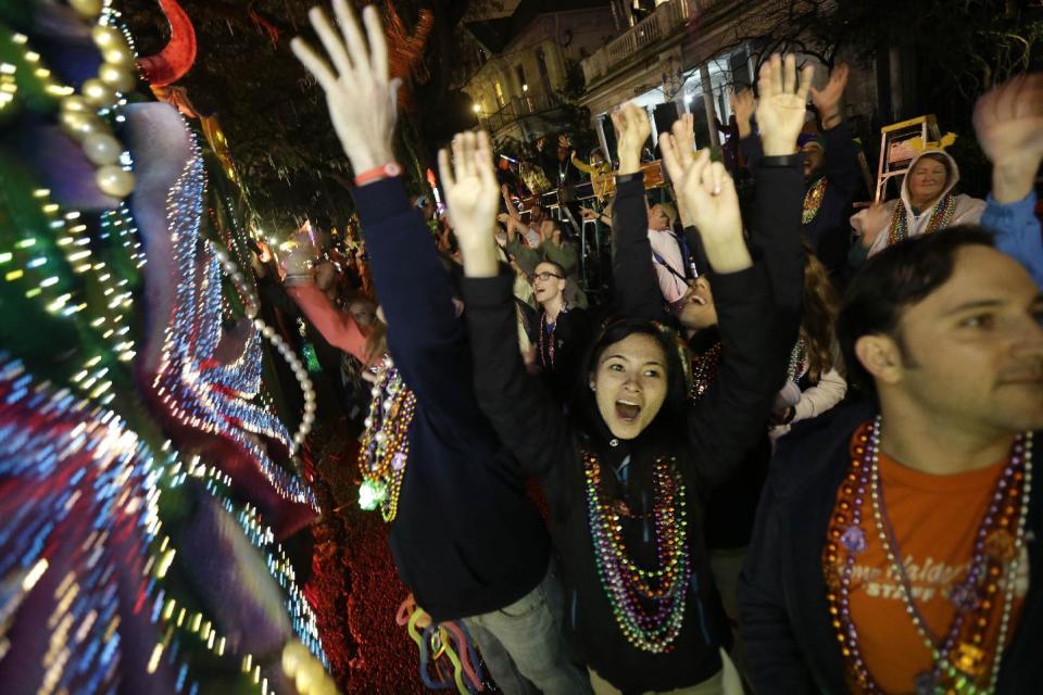 Revelers yell for beads and trinkets during the Krewe of Orpheus Mardi Gras parade in New Orleans, Monday, Feb. 11, 2013. (AP Photo/Gerald Herbert)