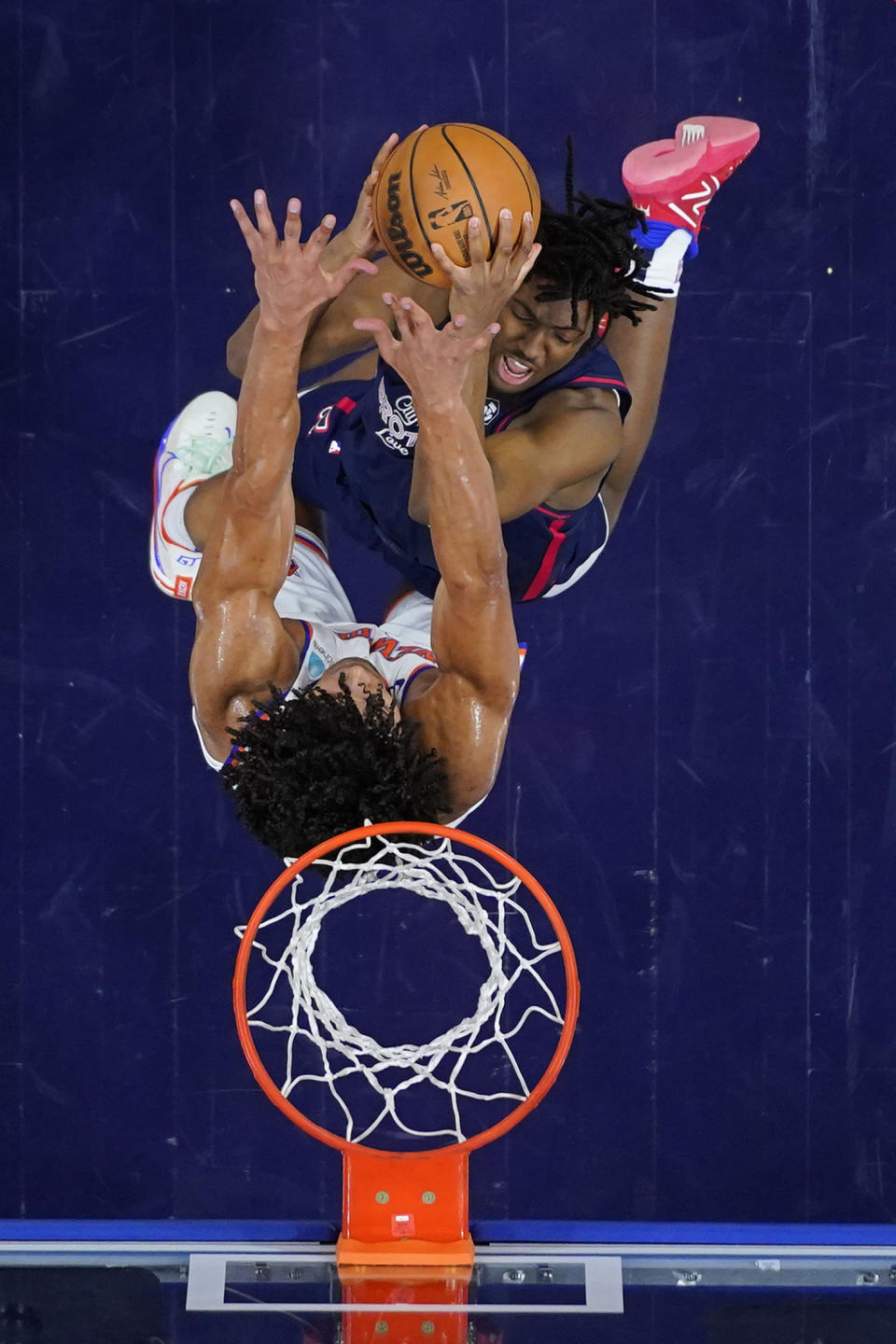 Philadelphia 76ers' Tyrese Maxey, top, tries to get a shot past New York Knicks' Jericho Sims during the first half of an NBA basketball game, Thursday, Feb. 22, 2024, in Philadelphia. (AP Photo/Matt Slocum)