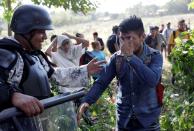 A migrant reacts next to a member of the security forces near Frontera Hidalgo