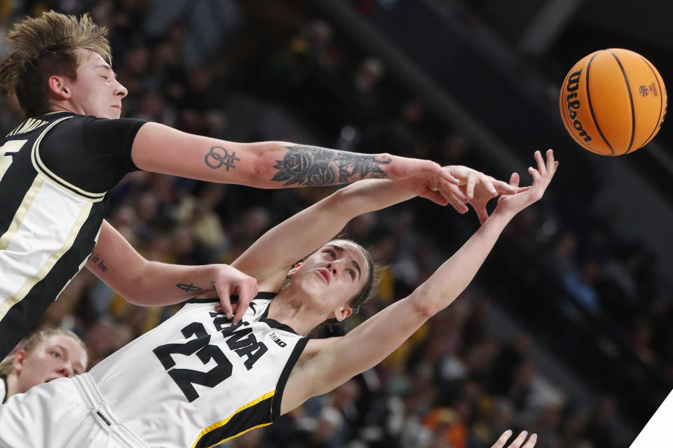 Purdue forward Rickie Woltman, left, knocks the ball away from Iowa guard Caitlin Clark (22) during the first half of an NCAA college basketball game at the Big Ten women's tournament Friday, March 3, 2023, in Minneapolis. (AP Photo/Bruce Kluckhohn)