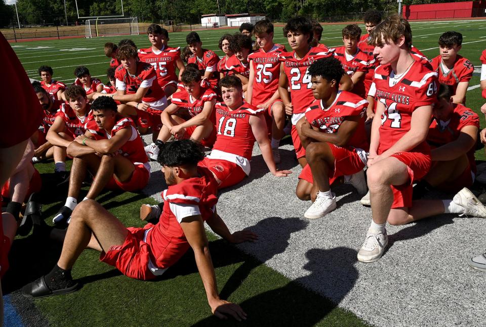 The Milford High School football team listens to head coach Dale Olson during media day, August 18, 2022.  
