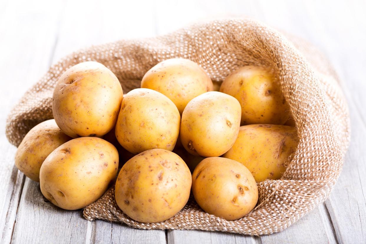 fresh potatoes on wooden table