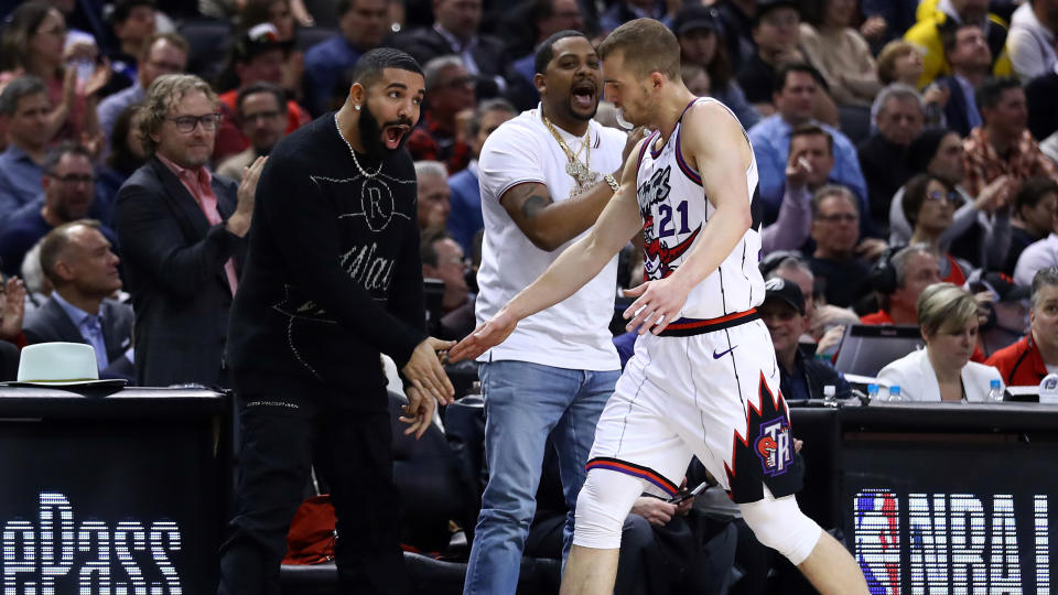 TORONTO, ON - FEBRUARY 25:  Singer Drake high fives Matt Thomas #21 of the Toronto Raptors during the first half of an NBA game against the Milwaukee Bucks at Scotiabank Arena on February 25, 2020 in Toronto, Canada.  NOTE TO USER: User expressly acknowledges and agrees that, by downloading and or using this photograph, User is consenting to the terms and conditions of the Getty Images License Agreement.  (Photo by Vaughn Ridley/Getty Images)