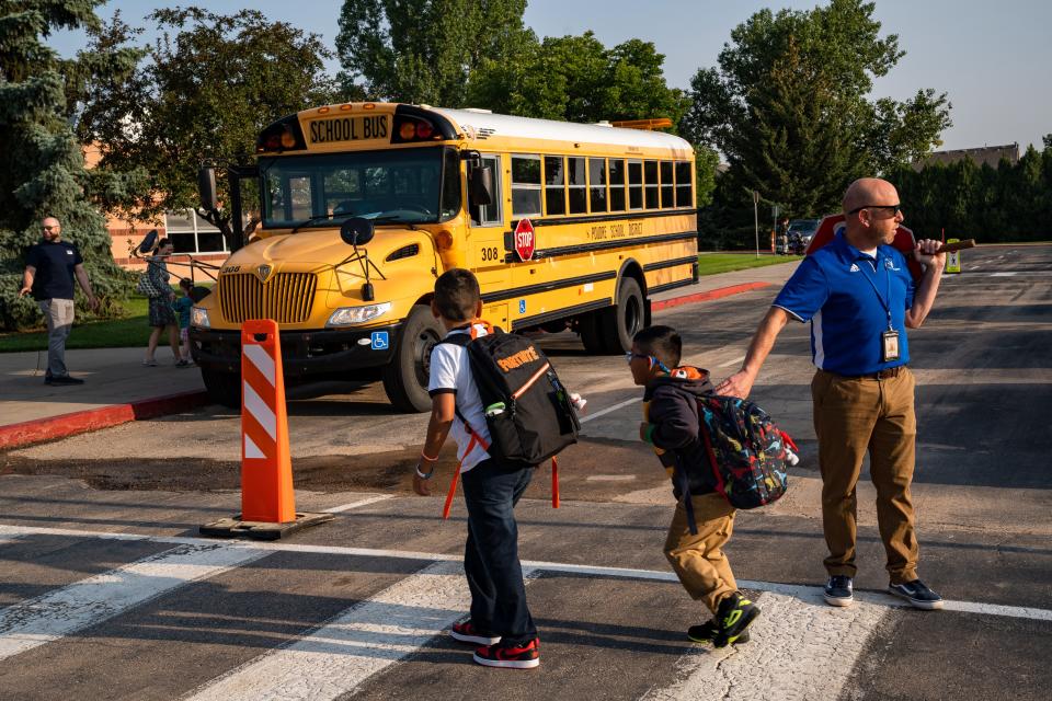 Principal Mark Strasberg watches the cross walk during the first day of school at Olander Elementary on Aug. 17 in Fort Collins.