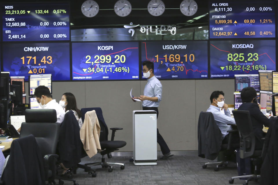 A currency trader walks by screens showing foreign exchange rates at the foreign exchange dealing room of the KEB Hana Bank headquarters in Seoul, South Korea, Thursday, Sept. 24, 2020. Asian shares were mostly lower Thursday as caution again after a retreat on Wall Street driven by a decline in technology shares. (AP Photo/Ahn Young-joon)