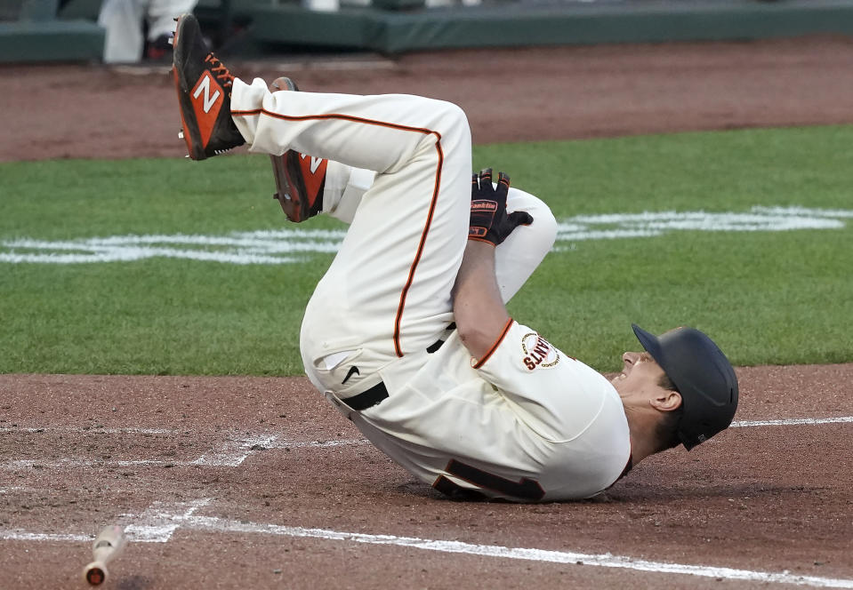 San Francisco Giants' Alex Dickerson reacts after getting hit by a ball that bounced off his bat during the fifth inning of a baseball game against the Arizona Diamondbacks, Monday, Sept. 7, 2020, in San Francisco. (AP Photo/Tony Avelar)