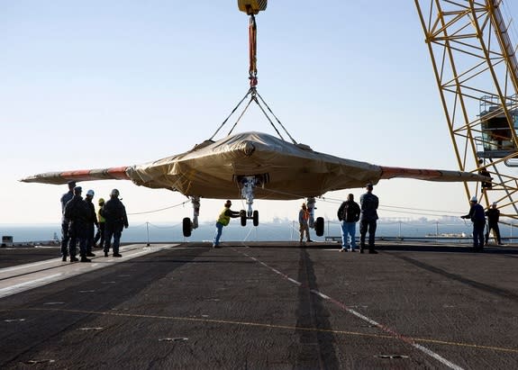 U.S. Navy Sailors assist with the onload of the X-47B Unmanned Combat Air System (UCAS) demonstrator aboard the aircraft carrier USS Harry S. Truman on Nov. 26, 2012.