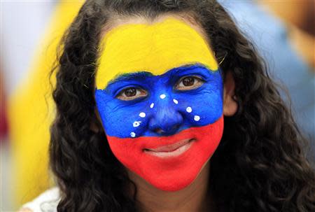 A girl with her face painted in the colors of the Venezuelan flag participates in a protest of Venezuelan citizens residing in Mexico, against the government of Venezuela's President Nicolas Maduro and the violence resulting from anti-government protests, in Mexico City February 23, 2014. AREUTERS/Henry Romero