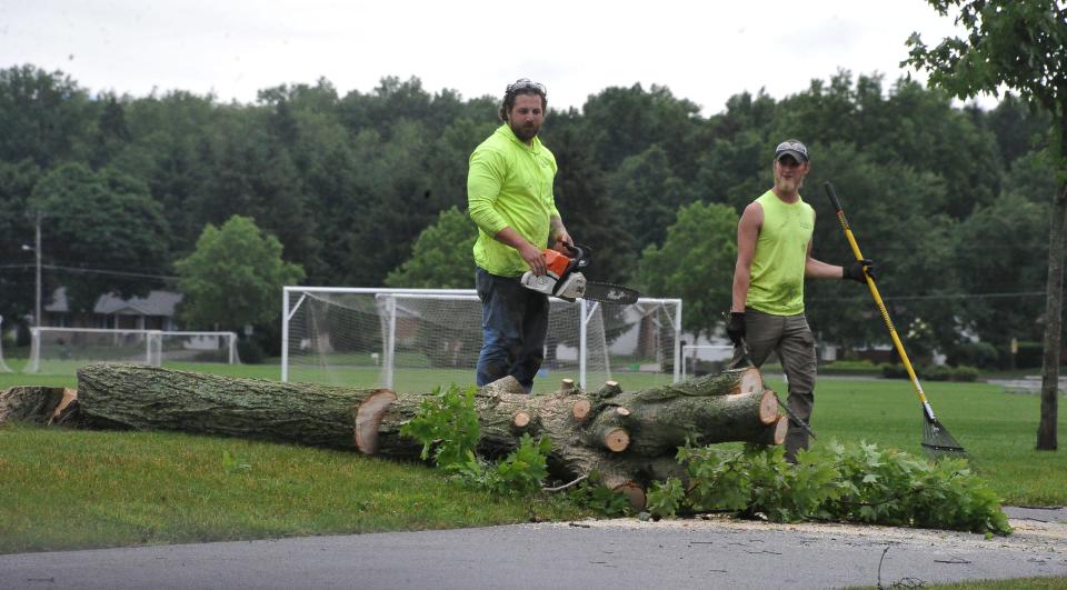 Crews clear a fallen tree at the Kinney building on Burbank Road in Wooster. Thousands were still without power in Wayne and Holmes counties Tuesday morning following an overnight severe thunderstorm that closed roadways, downed utility lines and caused some flash flooding.