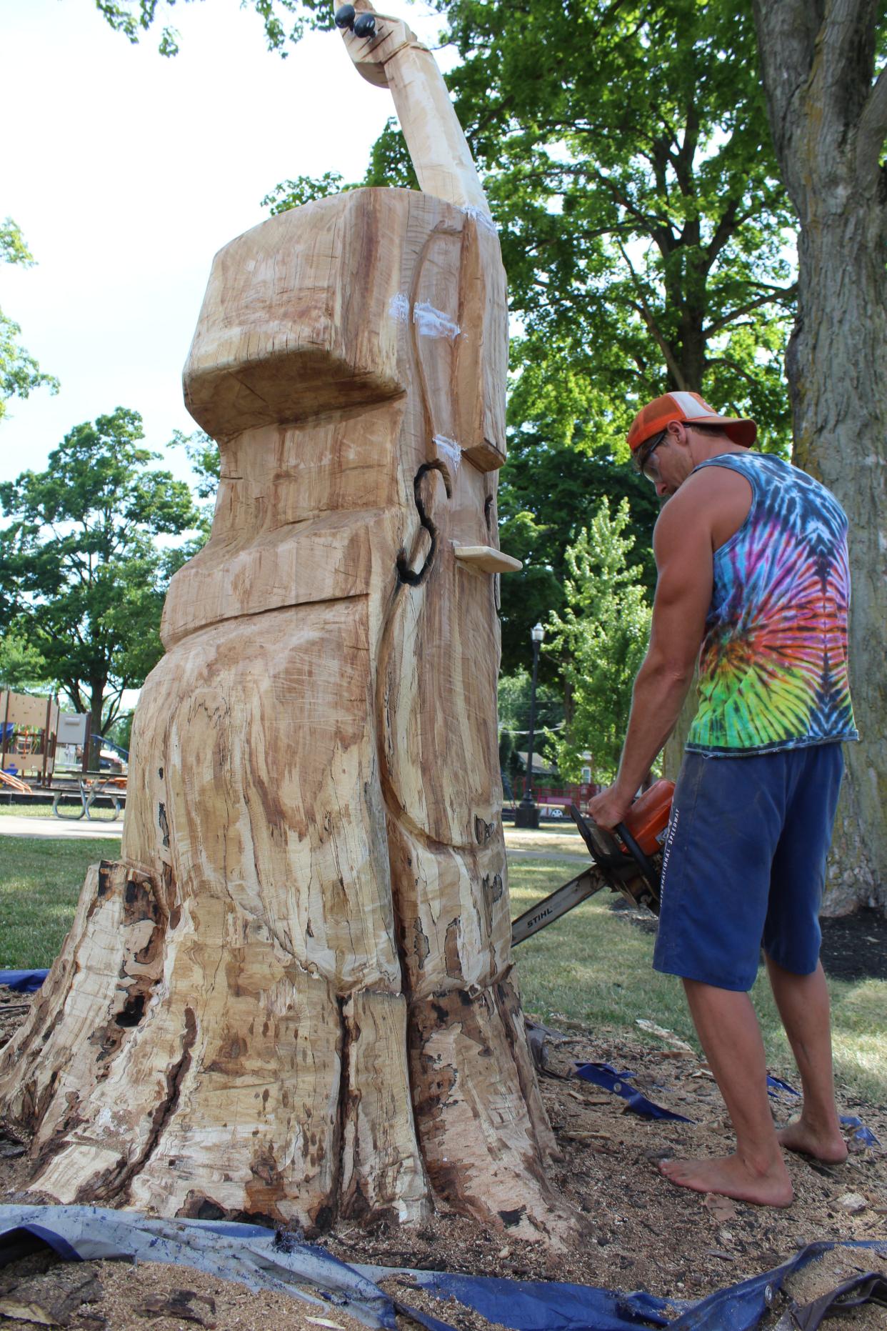 Thomas Naegele, a Quincy resident and chainsaw artist, has been turning a tree stump into a cello in Quincy Village Park. It is a nod to the many concerts in the park.