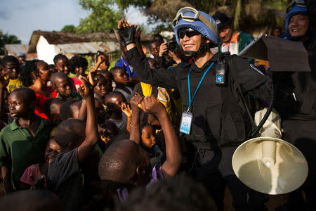 A member of the Chinese Formed Police Unit (FPU) deployed at UN Mission in Liberia (UNMIL) plays music and dances with children at the Steward Camp in Tubmanburg, during a long-range patrol, Liberia February 1, 2018. Albert Gonzalez Farran/UNMIL/Handout via REUTERS