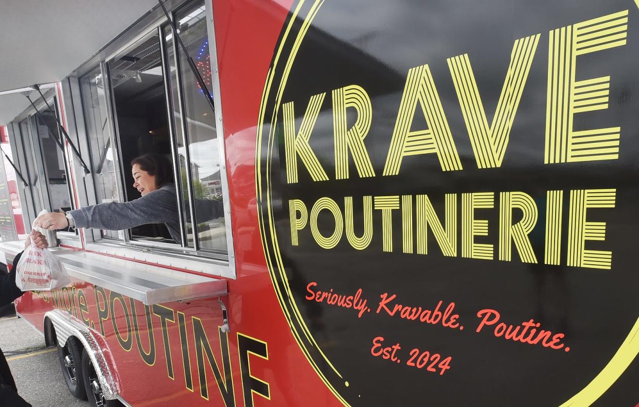 Owner Shelley Ring hands an order of Poutine to a customer at the Krave Poutinerie at 486 Bedford St. in Fall River Friday May 3 2024.