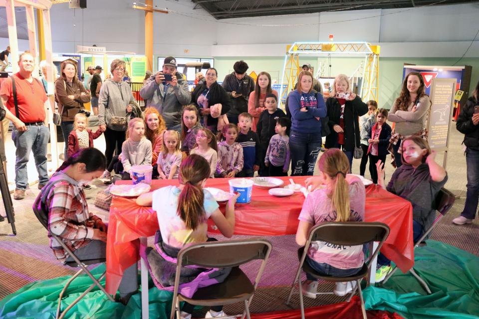 Family and friends cheer on participants racing to dig for gummy worms in a pie of whipped cream in this file photo as the Don Harrington Discovery Center celebrated Pi Day at a previous Spring Break Camp.